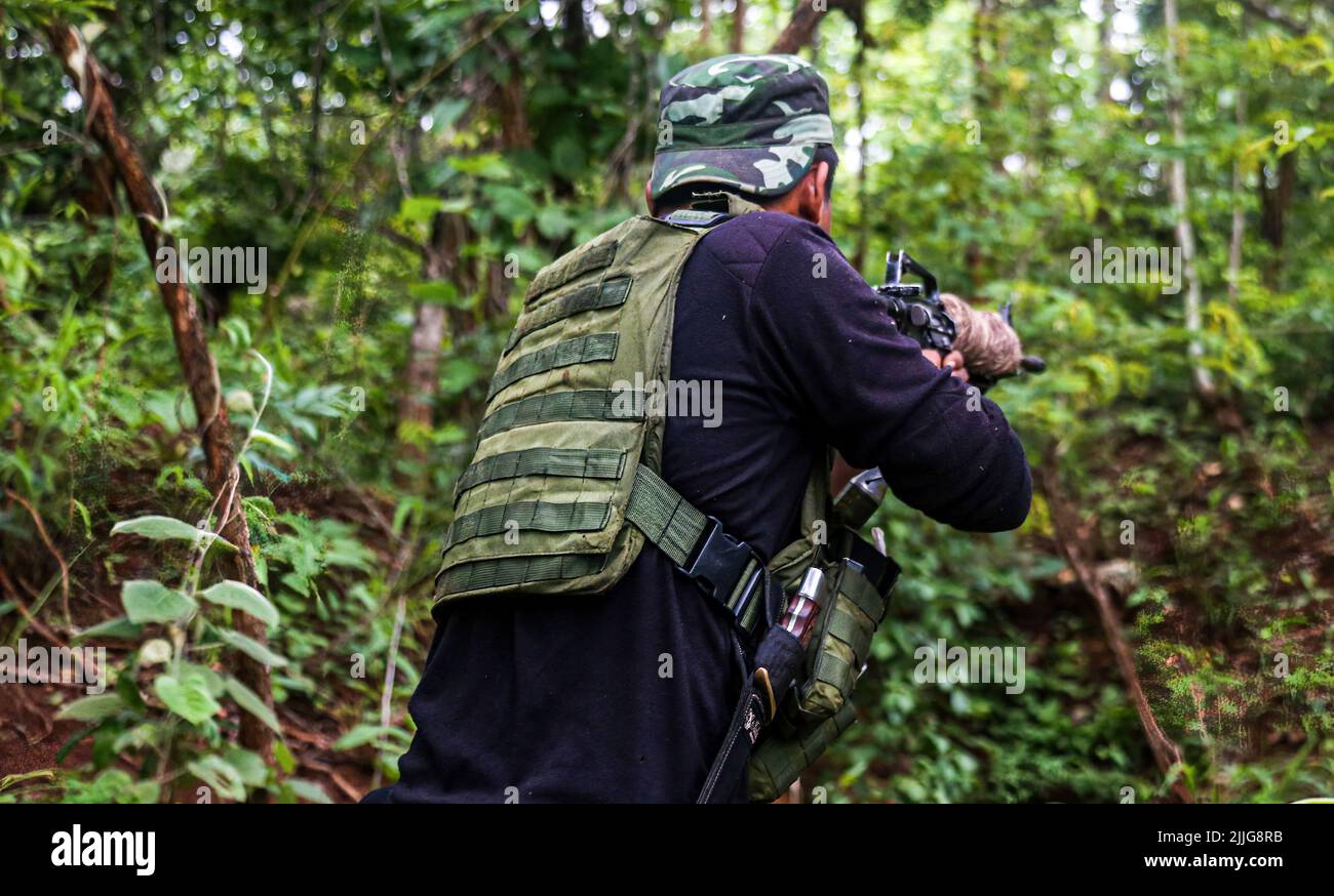 Während eines bewaffneten Konflikts mit der burmesischen Armee Tatmadaw wird ein Soldat der Karennischen Nationalitäten (KNDF) durch einen Dschungel geladen. Die Karenni Nationalities Defence Force (KNDF) ist eine bewaffnete aufständische Gruppe in Myanmar, die nach dem Staatsstreich von Myanmar im Jahr 2021 durch Oberbefehlshaber Min Aung Hlaing gebildet wurde. Zum KNDF gehören auch andere Organisationen wie die Karenni National Progressive Party (KNPP). Stockfoto