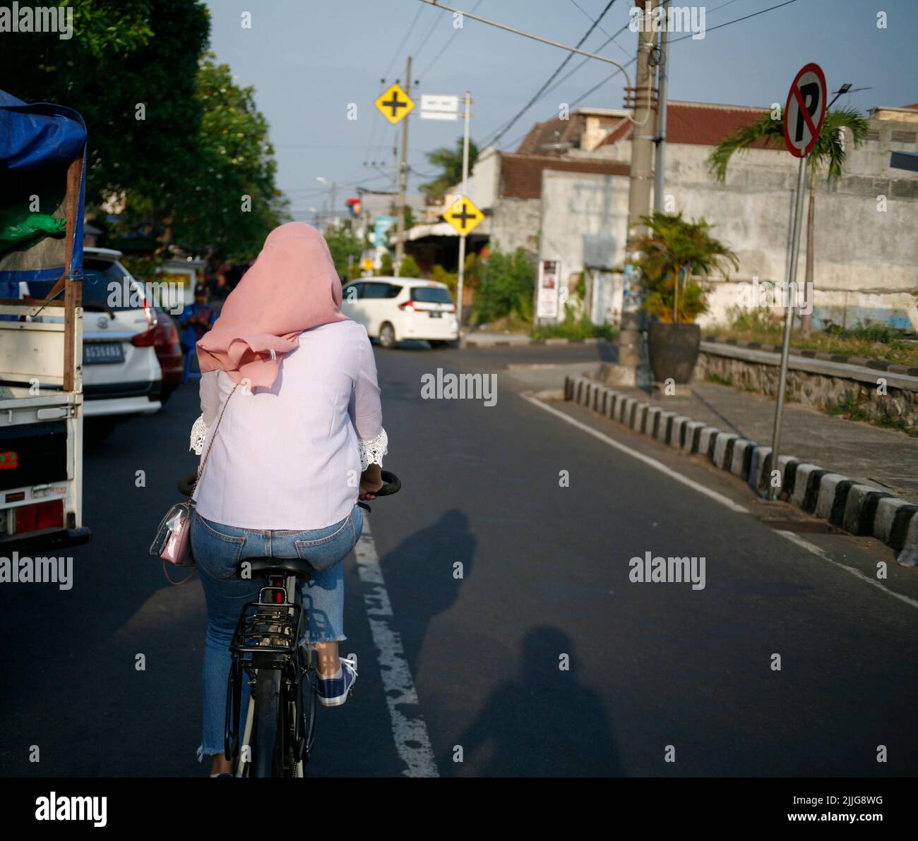 Junge Frau mit Kopftuch Radfahren Stockfoto