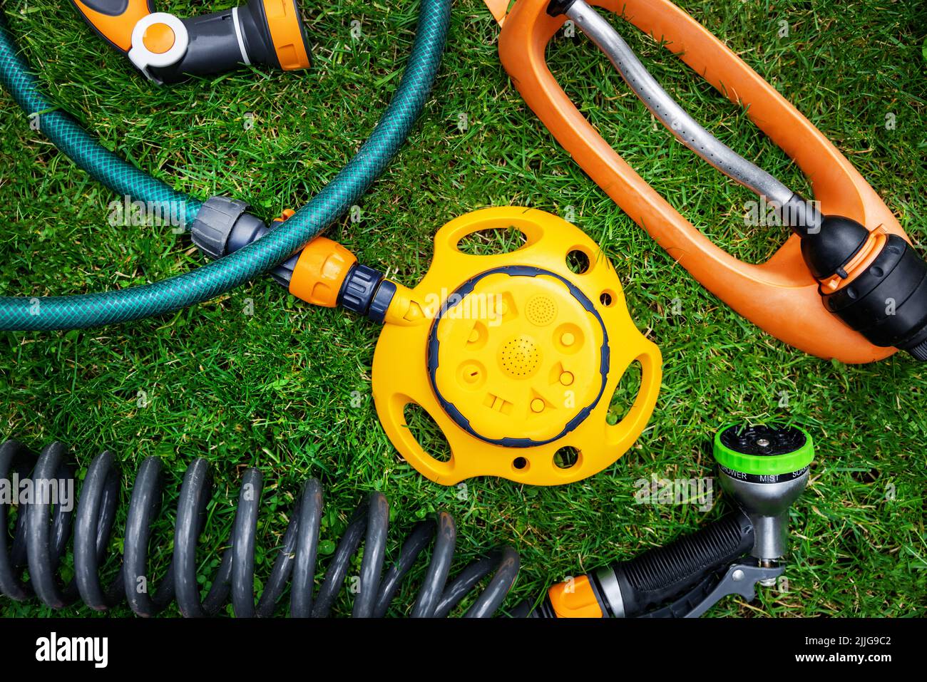Rasen- und Gartenbewässerungsgeräte. Sprinkler und Düsen auf Grashintergrund. Draufsicht Stockfoto