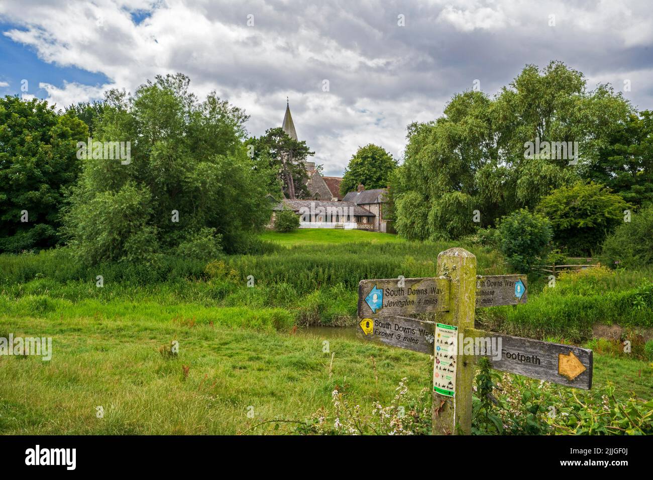 South Downs Way-Schilder neben dem Cuckmere River und der St. Andrew's Church in Alfriston, East Sussex. Stockfoto