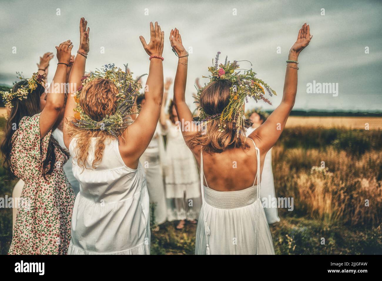 Frauen im Blumenkranz auf sonniger Wiese, Blumenkrone, Symbol der Sommersonnenwende. Stockfoto