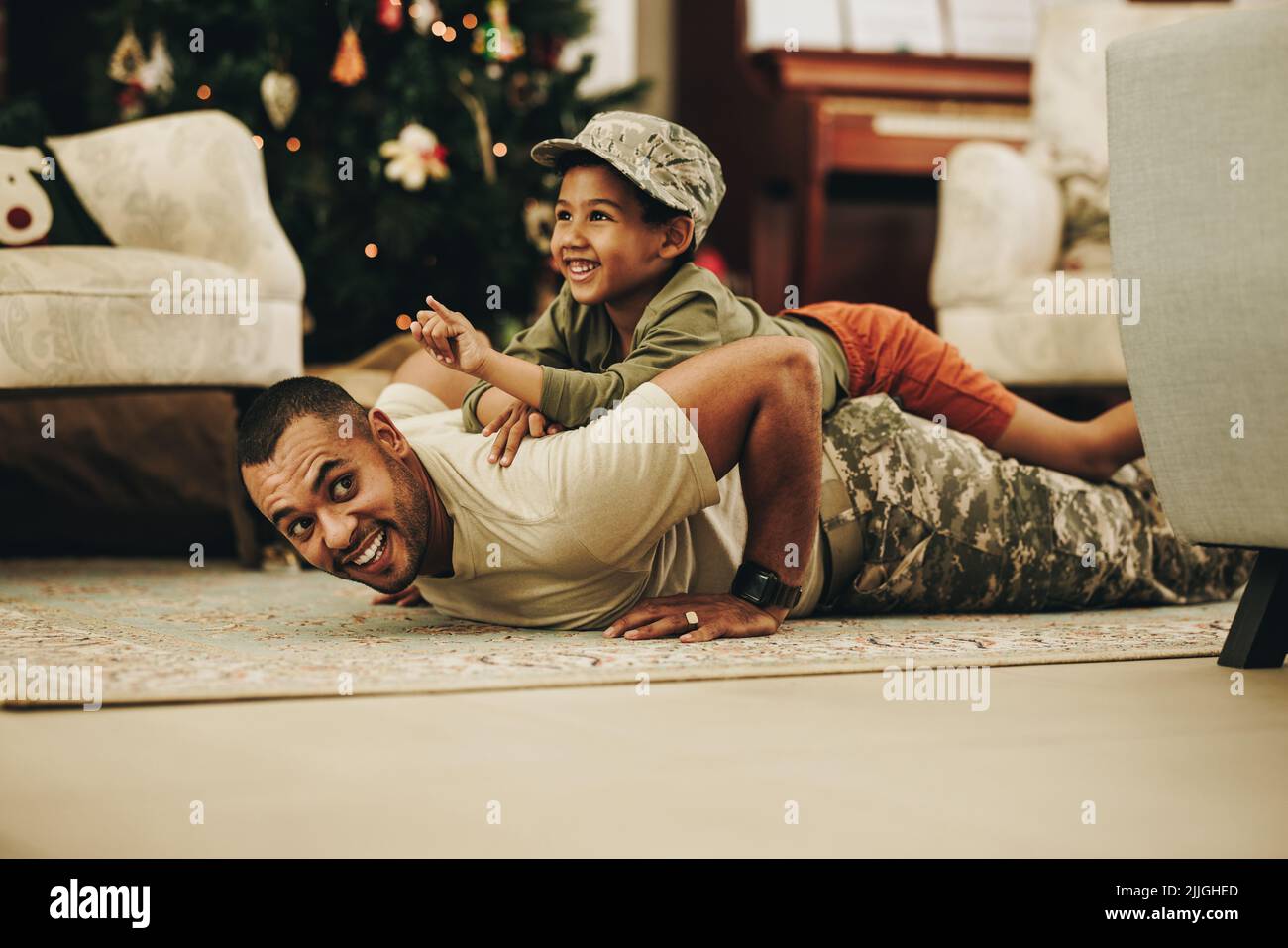 Vater und Sohn haben zu Weihnachten gemeinsam Spaß. Armeesoldat verbringt die Ferien mit seinem Kind nach dem Einsatz. Militär Vater mit einem verspielten reu Stockfoto