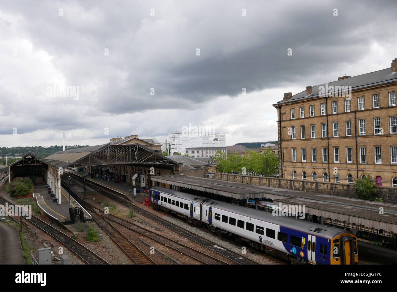 Silber und blau zwei Wagen nördlichen Eisenbahn-Zug in Station geparkt anderen Linien und Gebäuden wolkigen Himmel Stockfoto