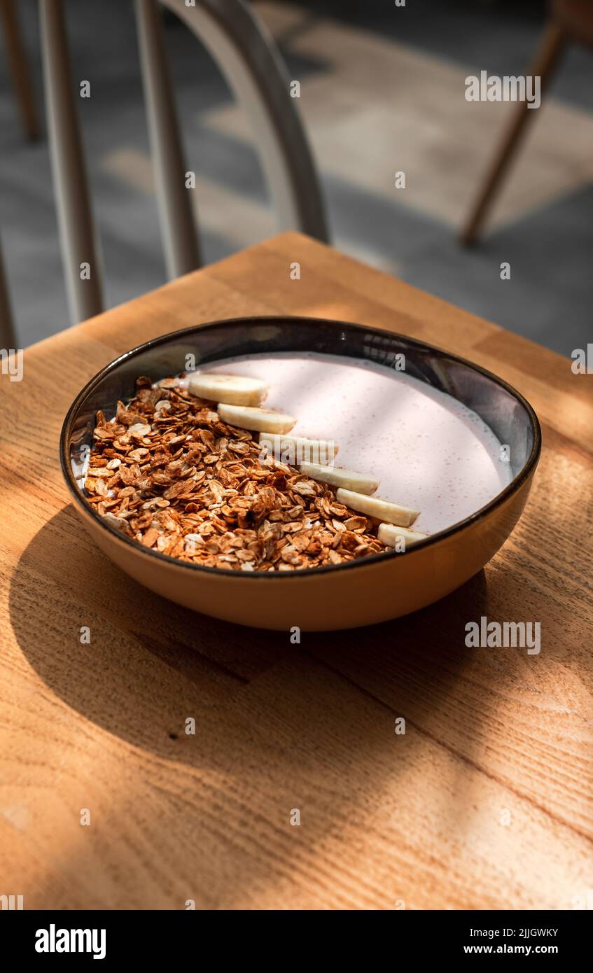 Die vertikale Ansicht einer Schüssel mit Getreide auf dem Holztisch Stockfoto