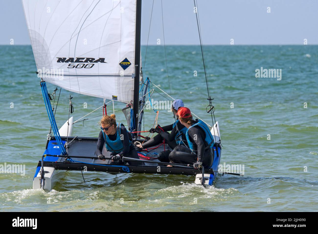 Drei Frauen segeln mit einem ausnehmbaren Katamaran auf See Stockfoto