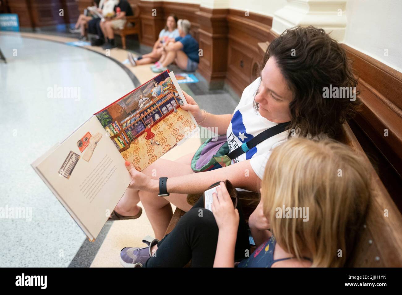 Austin Texas USA, Juli 26 2022: Mama JESSE NEUFELD und Tochter RUBY SUNESON, 6, protestieren gemeinsam mit anderen Aktivisten gegen Buchzensur in öffentlichen Schulklassen und Bibliotheken. Die Demonstranten saßen in der Rotunde des Kapitols und lasen einige der 850 Bücher, die auf der Liste der „unbequemen“ Titel eines republikanischen Gesetzmachers aufgeführt waren. Kredit: Bob Daemmrich/Alamy Live Nachrichten Stockfoto