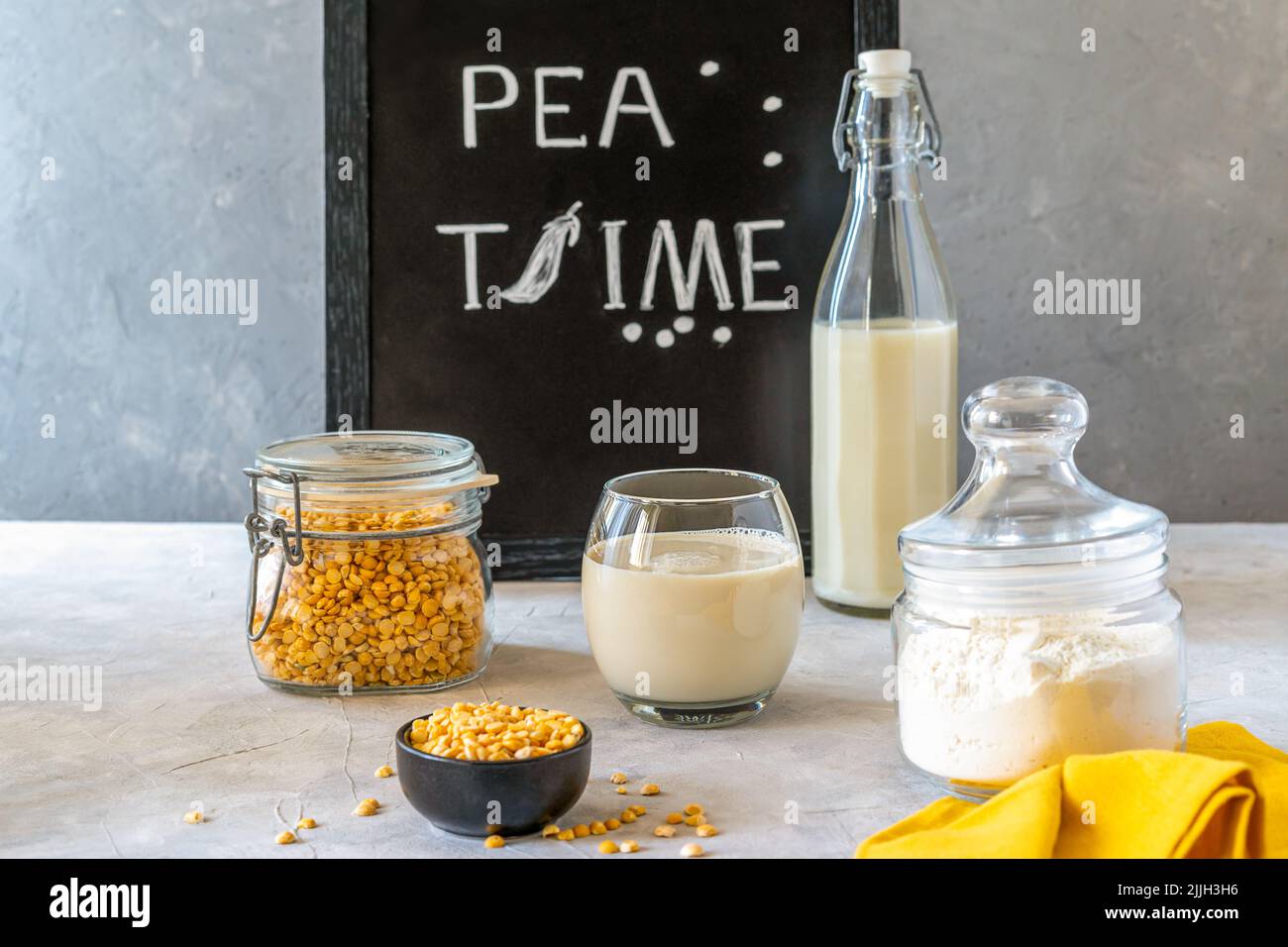 Gesunde Erbsenprodukte - Milch, Mehl und Samen. Konkreter Hintergrund, Mockup für Text Stockfoto