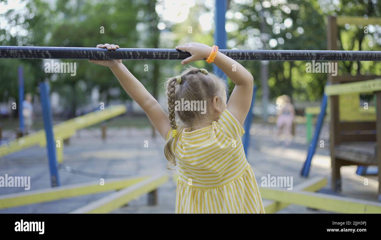 Nettes kleines Mädchen spielt auf dem Spielplatz. Kind Mädchen spielt auf dem Spielplatz im Stadtpark Stockfoto