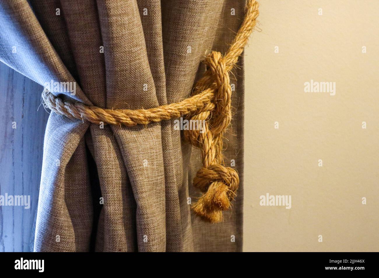 Geflochtenes Seil Strumpfband auf dem Vorhang Nahaufnahme. Interieur Detail Stockfoto