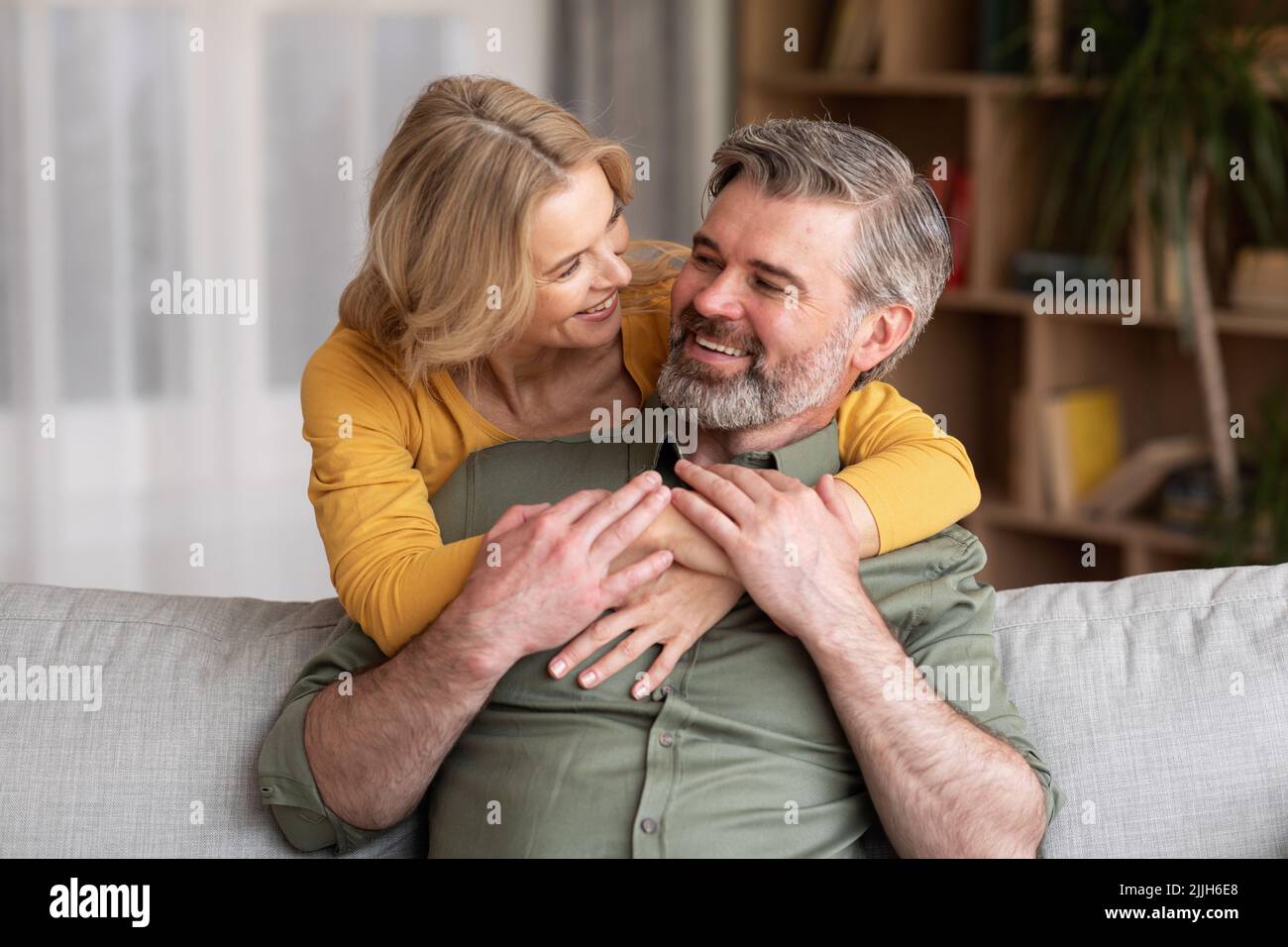 Inländische Romantik. Portrait Of Loving Eried Middle Aged Pärchen Hugging At Home Stockfoto