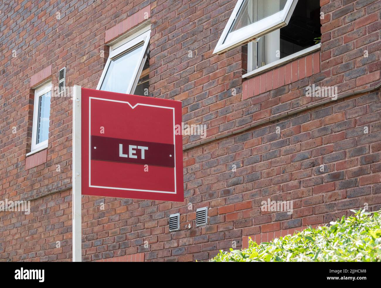 Ein Immobilienmakler ließ Zeichen vor einem Wohnblock, wo Immobilien zur Miete sind Stockfoto