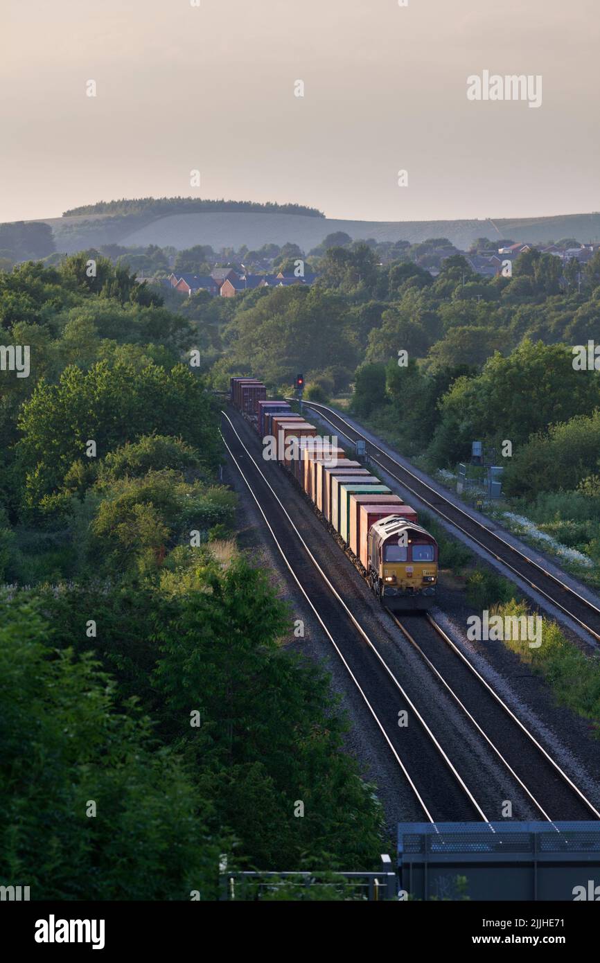 DB Cargo Rail UK Diesellokomotive der Baureihe 66, die Bennerley im Erewash Valley, Nottinghamshire, Großbritannien, mit einem Güterzug mit Containern passiert Stockfoto