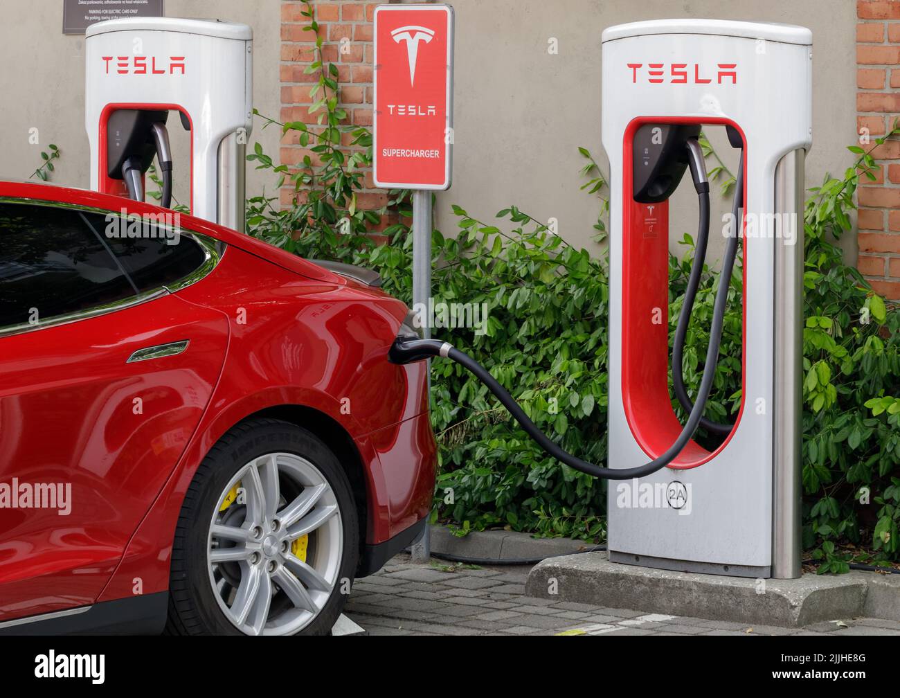 Posen, Polen. 26 Jul 2022: Ein schönes rotes Tesla-Elektro-Pkw füllt seine Batterie an einer Ladestation auf. Nahaufnahme Stockfoto
