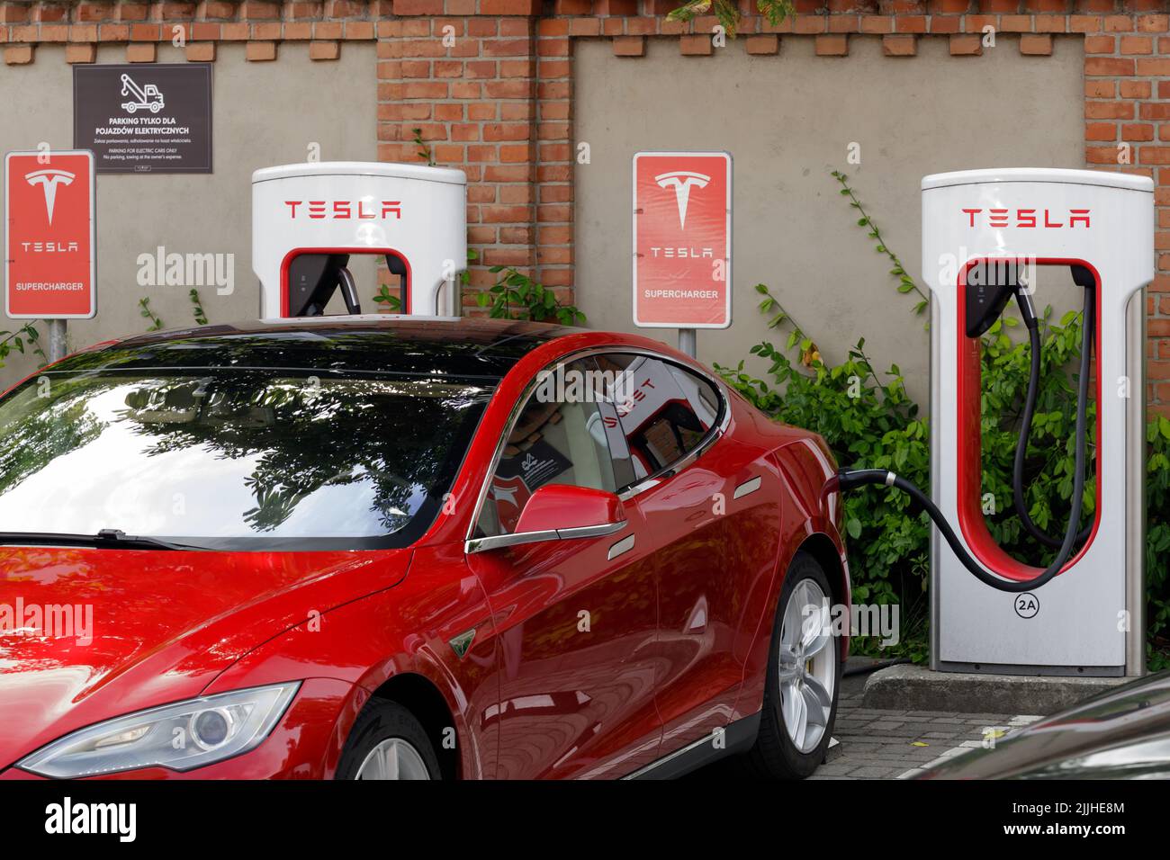 Posen, Polen. 26 Jul 2022: Rote Tesla-Elektroautos ergänzen die Batterie an der Ladestation, alternative Energie. Schnellladestation Stockfoto