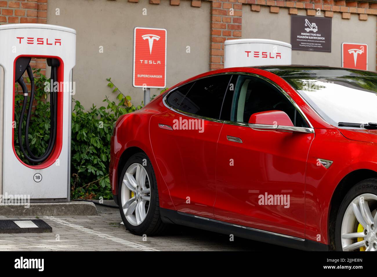 Posen, Polen. 26 Jul 2022: Elektroauto beim Laden an einer Tesla-Schnellladestation. Roter Tesla. Stockfoto