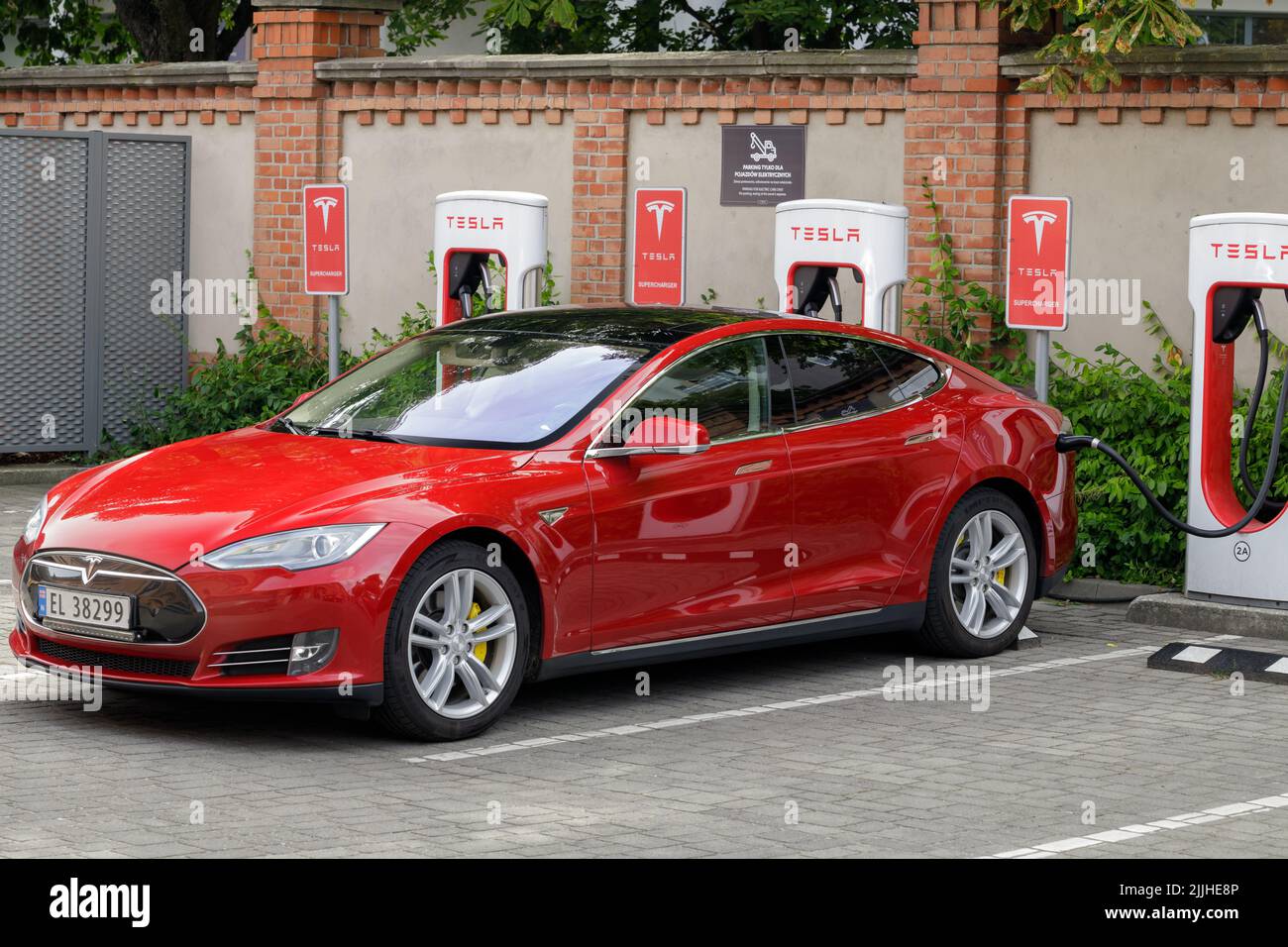 Posen, Polen. 26. Jul 2022: Ein roter Tesla lädt an einer Tesla Supercharger-Station in Poznan, Polen. Stockfoto