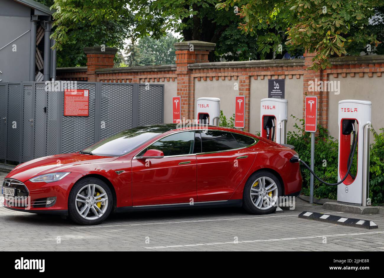 Posen, Polen. 26 Jul 2022: Rote Tesla-Autos laden an einer Tesla-Kompressorstation. Kompressorstationen ermöglichen das schnelle Aufladen von Autos online per wlan Stockfoto