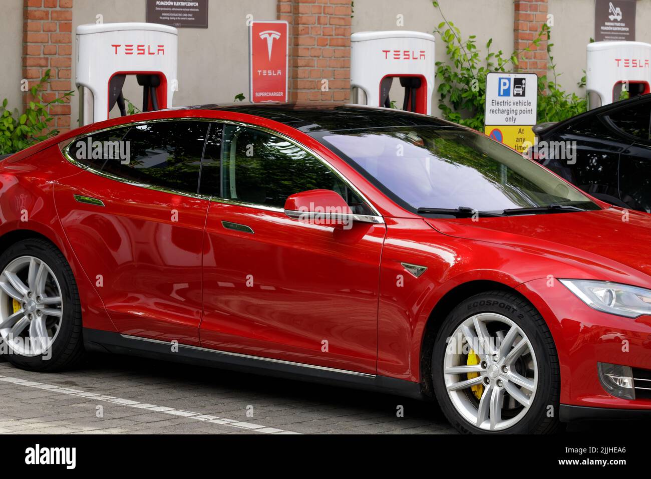 Posen, Polen. 26 Jul 2022: Tesla Super Ladestation auf Parkplatz mit Ladefunktion . Tesla-Kompressorstationen ermöglichen Tesla-Autos, schnell zu chargen Stockfoto