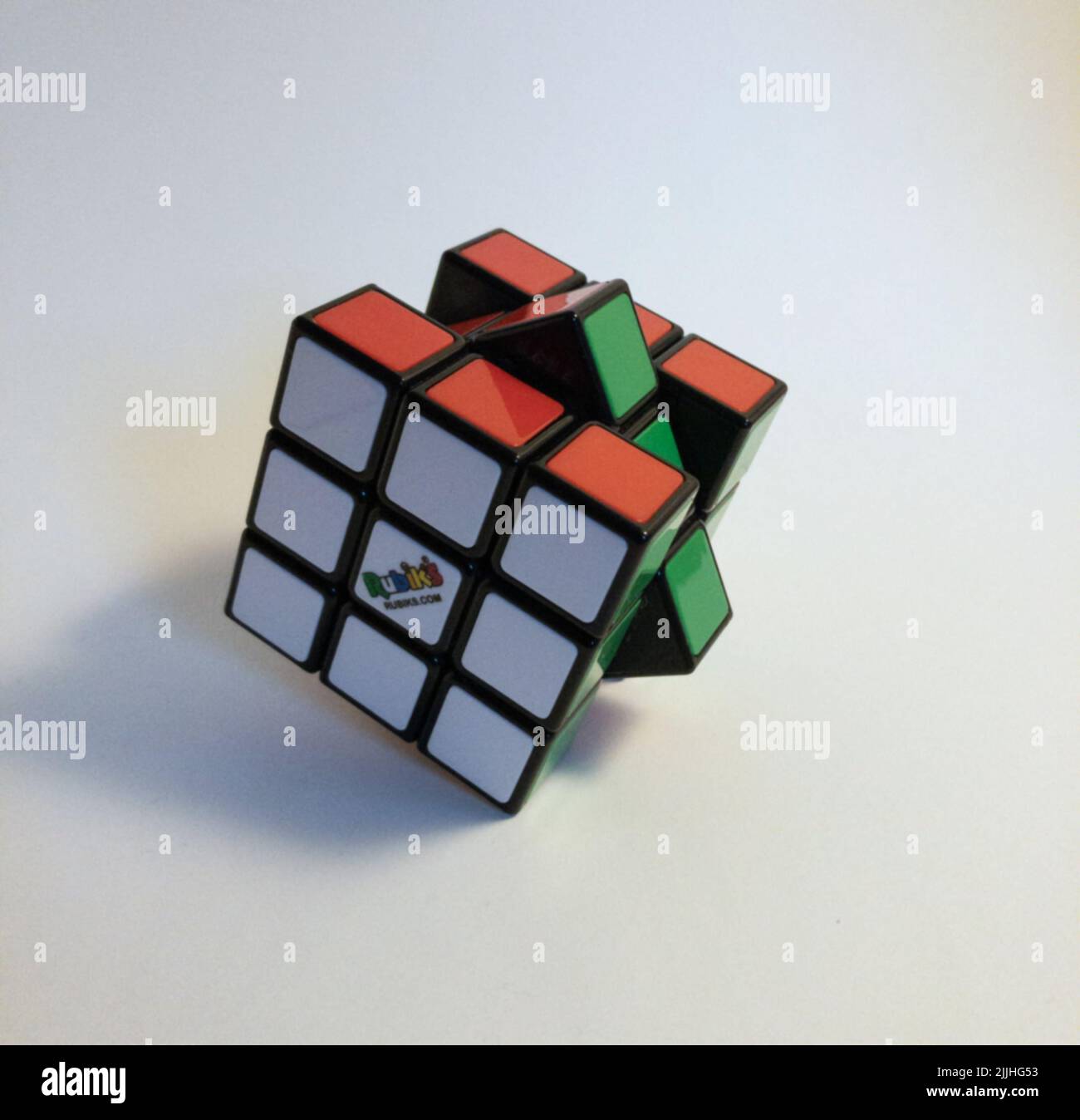 Ein gelöster Rubik's Cube mit dem Mittelteil, der leicht auf weißer Oberfläche bewegt wurde Stockfoto