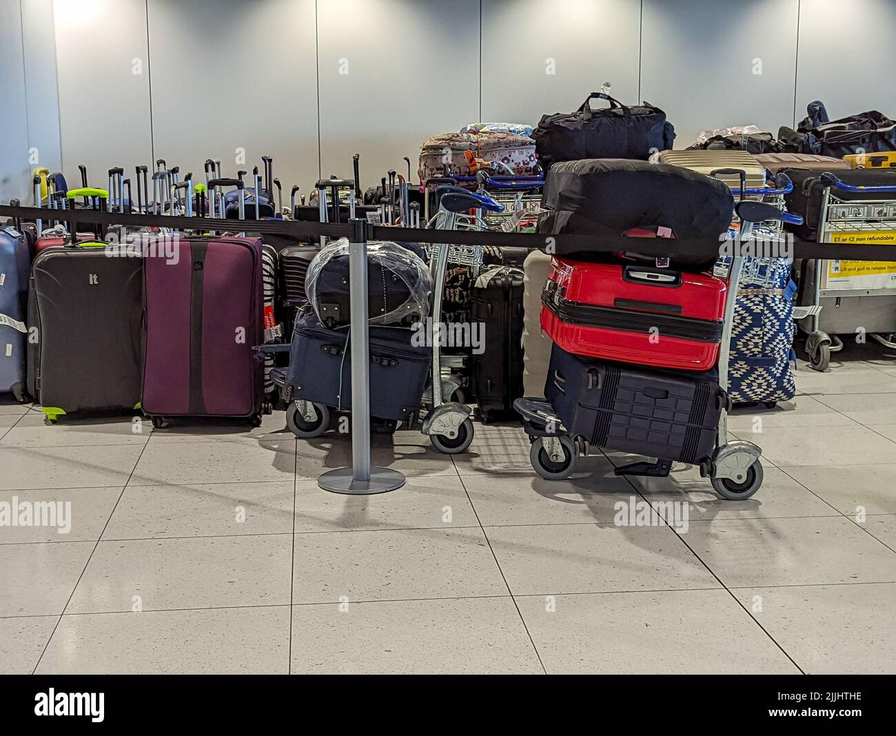 MANCHESTER, VEREINIGTES KÖNIGREICH - JULI 24. 2022: Stapel verspäteter Gepäckstücke warten am Flughafen von Manchester Stockfoto