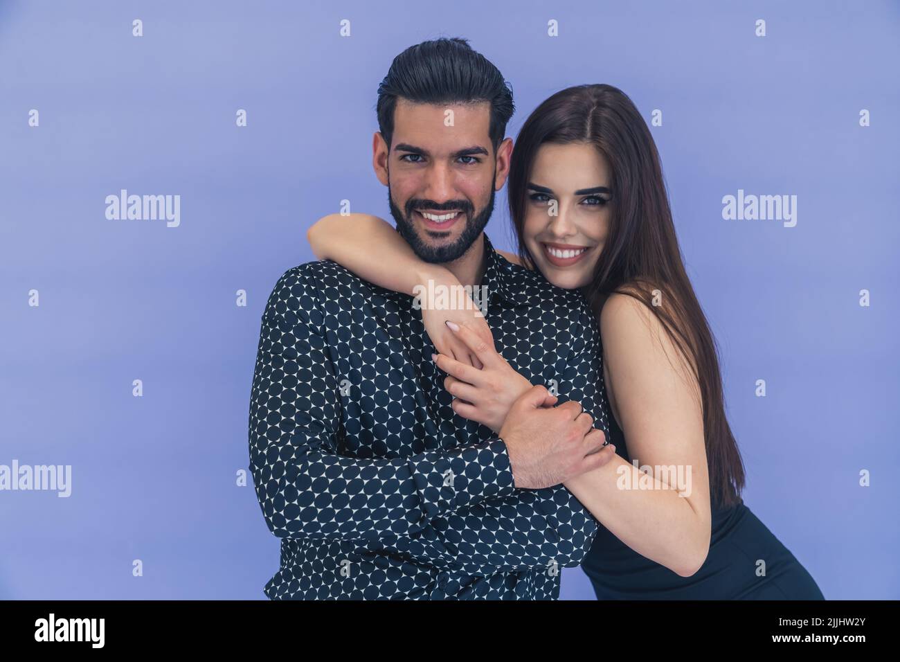 Glückliches Paar lächelt und umarmt sich auf blauem Hintergrund Stockfoto