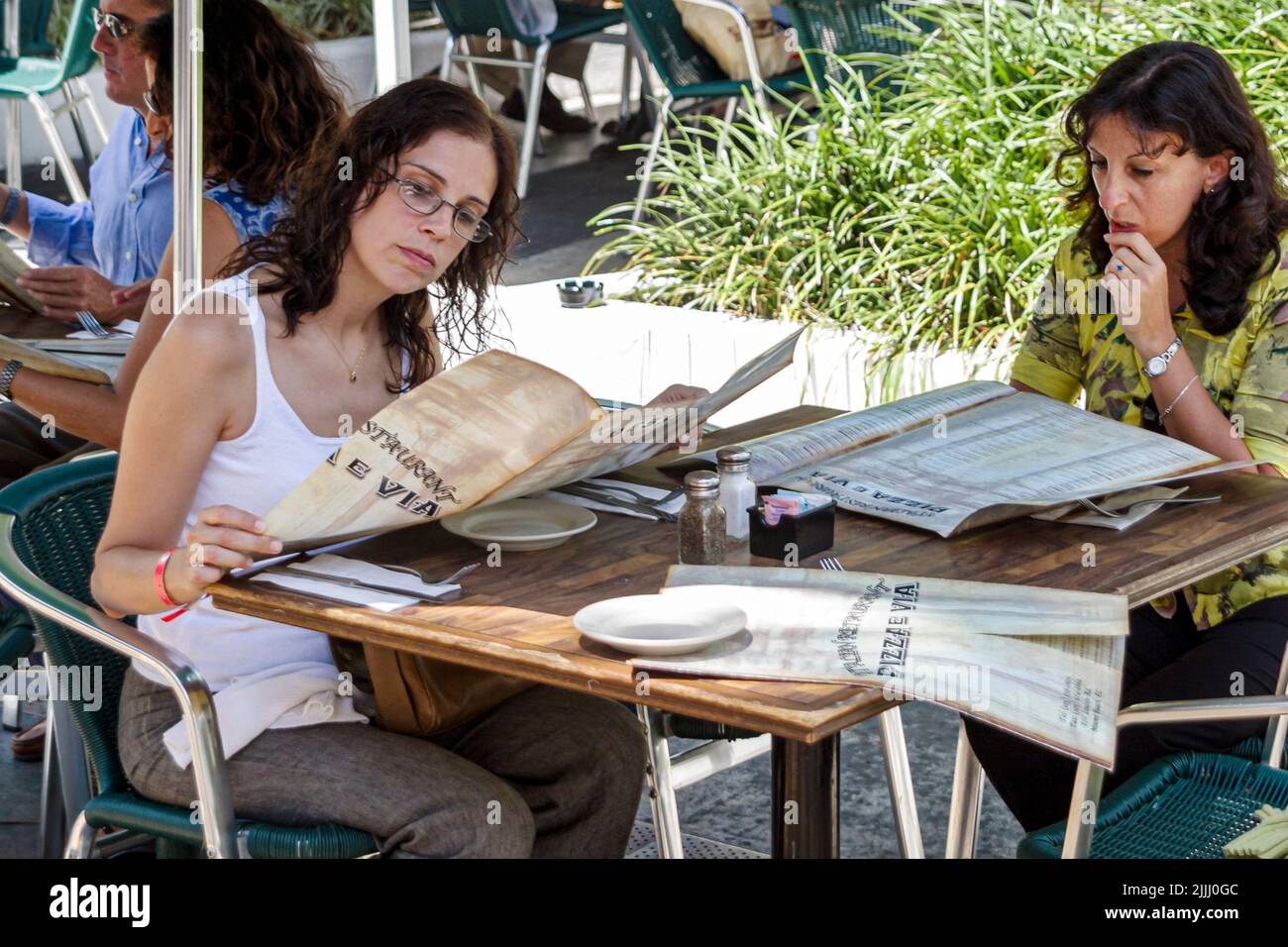 Miami Beach, Florida, Lincoln Road, Fußgängerzone, Außenterrasse mit Außenterrasse, Restaurant, in dem Frauen essen, Freunde, die die Speisekarte lesen und sich entscheiden Stockfoto