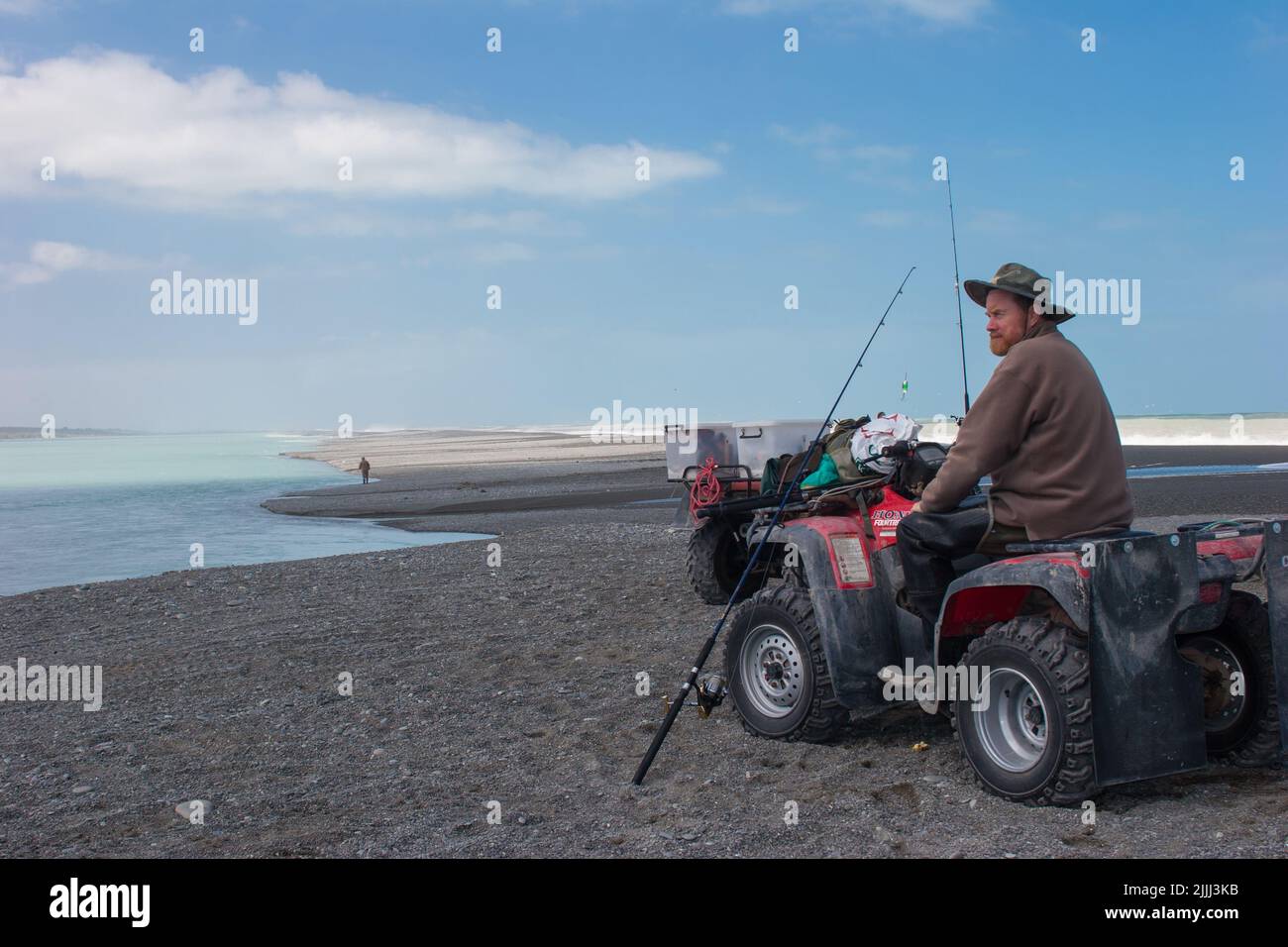 Ein Blick auf das Leben in Neuseeland: Lachsfischen an einem Flussufer, mit dem Quadbike. Stockfoto