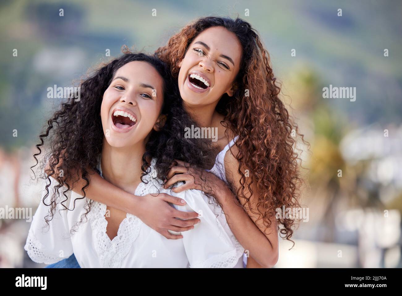 Ich und meine Bestie, leben jung, wild und frei. Zwei junge Frauen genießen eine Huckepack-Fahrt im Freien. Stockfoto