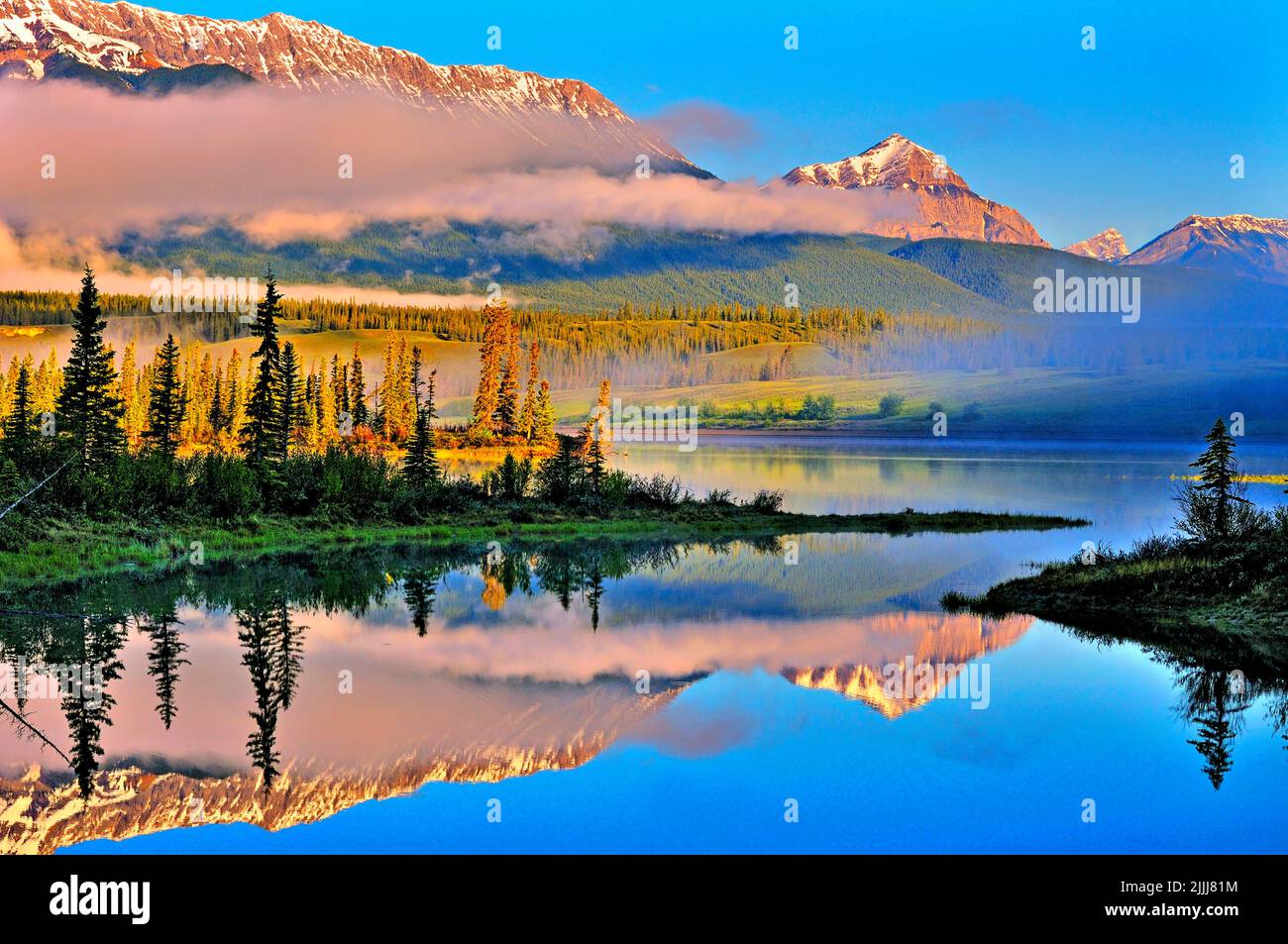 Eine neblige Morgenspiegelung einer felsigen Bergkette im friedlichen Athabasca-Fluss im Jasper National Park Alberta Canada Stockfoto