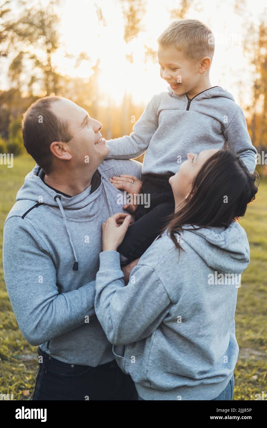 Fröhlicher Vater und Mutter, die mit ihren Kindern im Park spielen. Liebe Zeit. Gesunder Lebensstil. Frohe, liebevolle Familie. Stockfoto