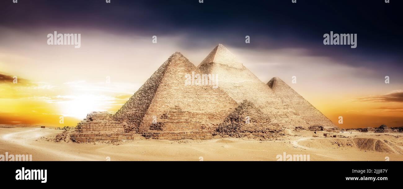 Malerisches Foto der Großen Pyramiden von Gizeh, aufgenommen bei einem malerischen, romantischen Sonnenuntergang. Die fast imposantesten antiken Wunder der Welt. Stockfoto