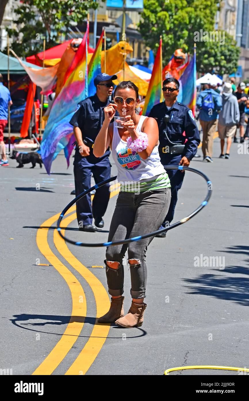 Lächelnde Frau mit Reifen während der Veranstaltung Sunday Streets Tenderloin in San Francisco, USA. Es ist freie Nachbarschaft Unterhaltung Stadt Street Festival. Stockfoto