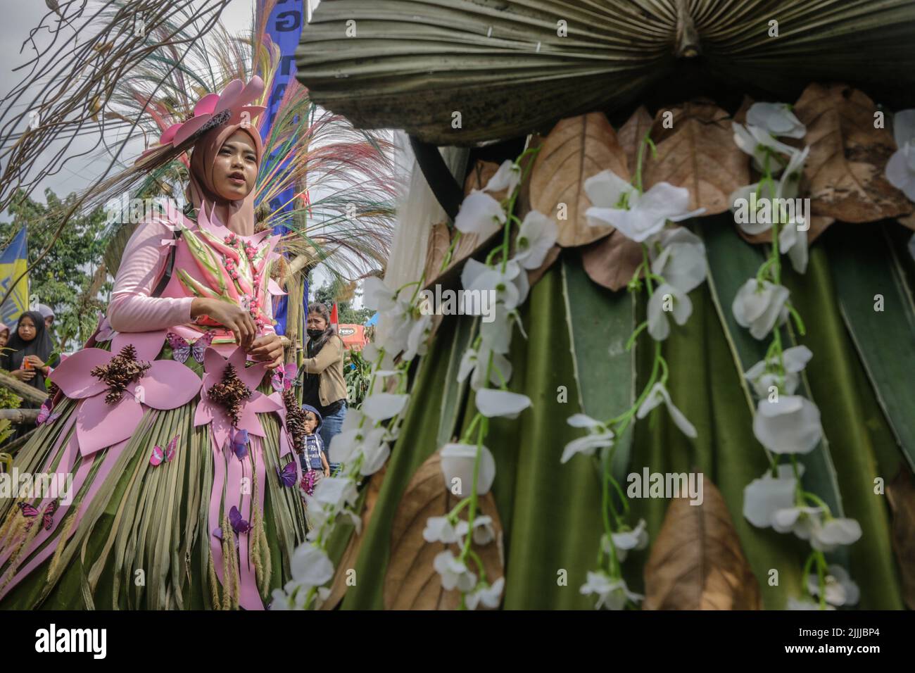 Eine Frau im Naturkleid aus Blättern, Blumen, Wurzeln, nimmt an einer Naturmodeparade 'Zurück zur Natur Kulturerhaltung' Teil Stockfoto