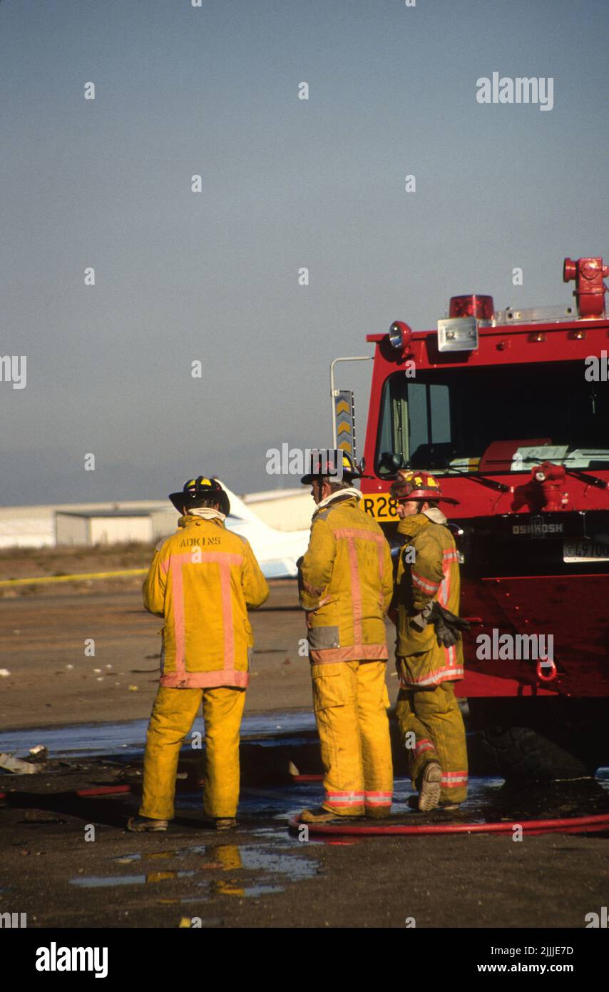 San Diego Feuerwehrleute stehen neben der SDFD Crash Rescue 28 nach dem Absturz eines USMC Cobra Hubschraubers auf dem Montgomery Field in San Diego Stockfoto