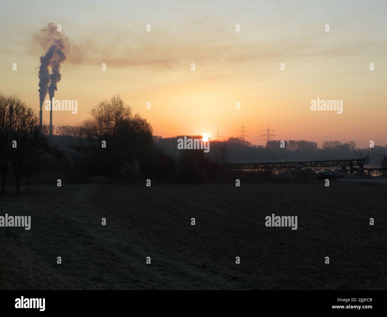 Malerischer Blick auf das Rheintal bei Sonnenaufgang im Frühling mit rauchenden Kaminen im Hintergrund Stockfoto