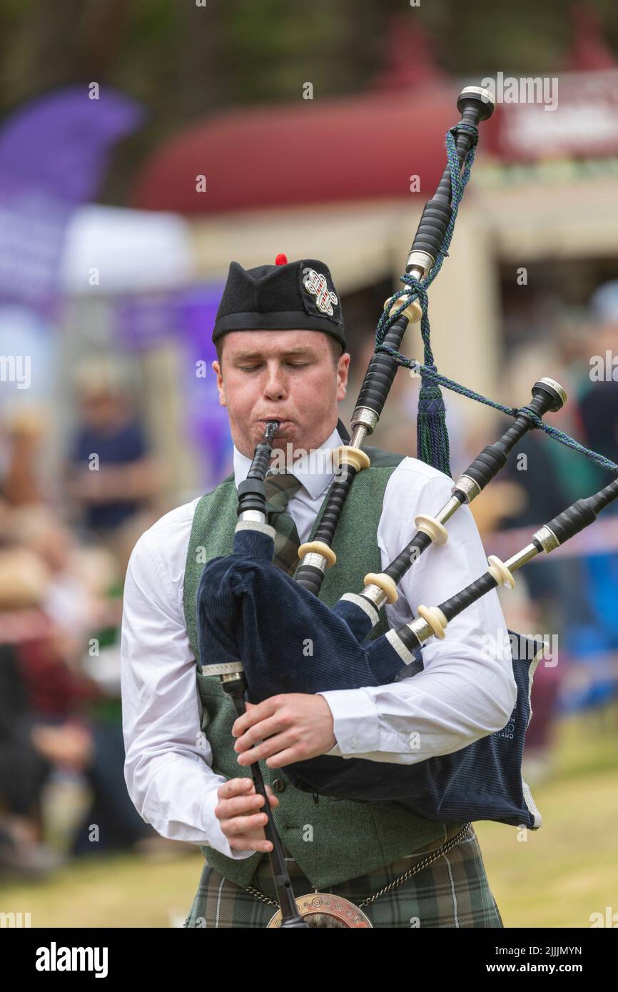 Highland-Spiele, die am 17. Juli 2022 in Tomintoul Moray in Schottland stattfinden, spielt ein schottischer Mann vor der Jury in Schottland, Großbritannien, die Dudelsäcke Stockfoto