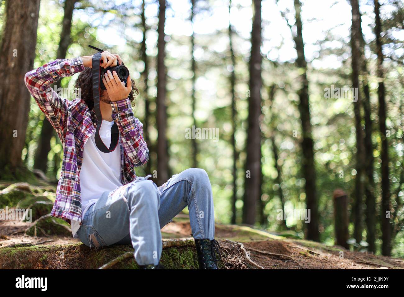 Gesichtslose Fotografin, die in Costa Rica mit der Kamera direkt in den Wald schaut Stockfoto
