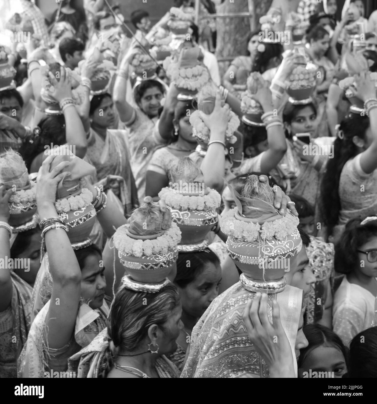 Delhi, Indien April 03 2022 - Frauen mit Kalash am Kopf während des Jagannath-Tempels Mangal Kalash Yatra tragen indische Hindu-Anhänger irdische Töpfe im Container Stockfoto