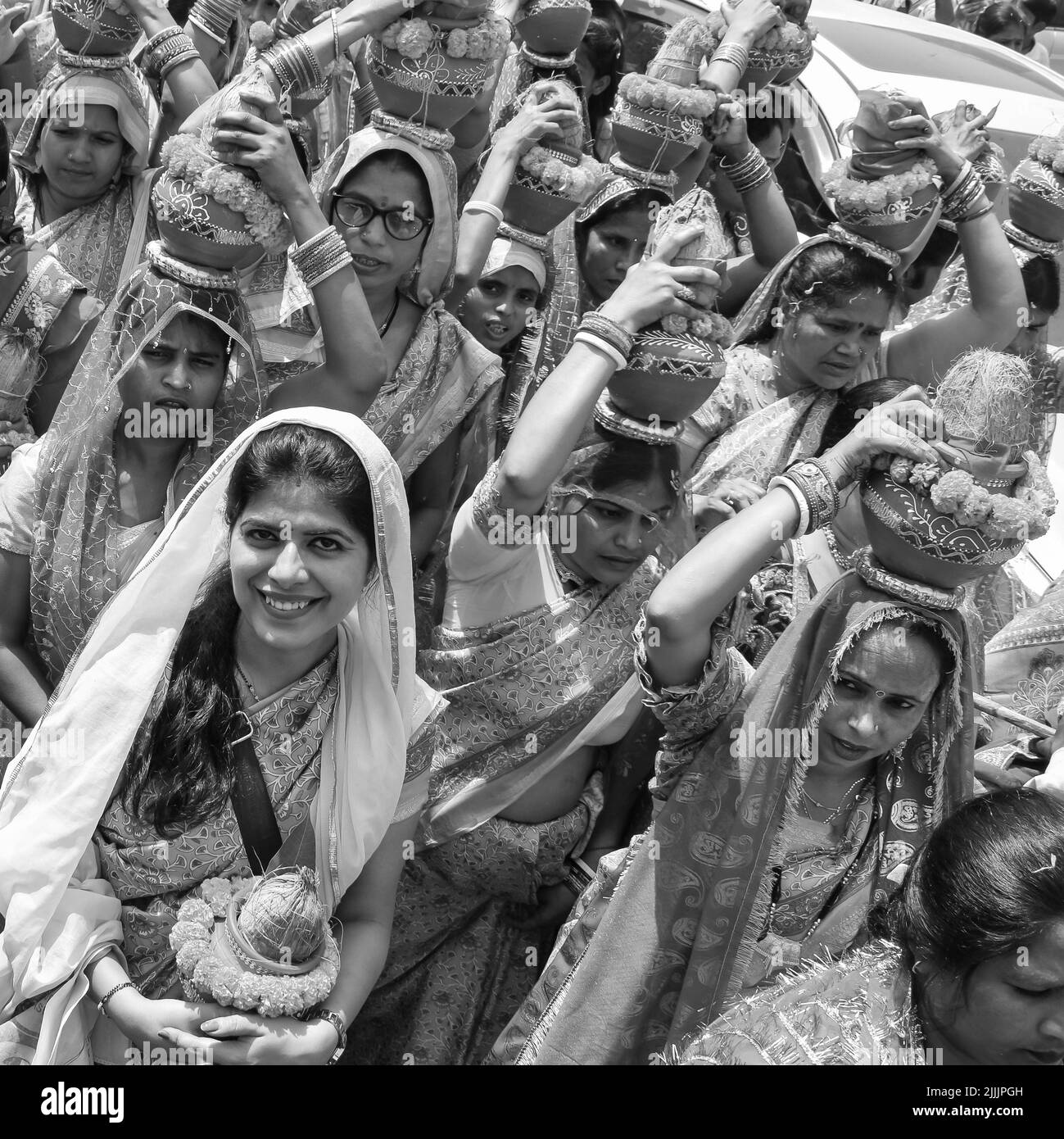 Delhi, Indien April 03 2022 - Frauen mit Kalash am Kopf während des Jagannath-Tempels Mangal Kalash Yatra tragen indische Hindu-Anhänger irdische Töpfe im Container Stockfoto