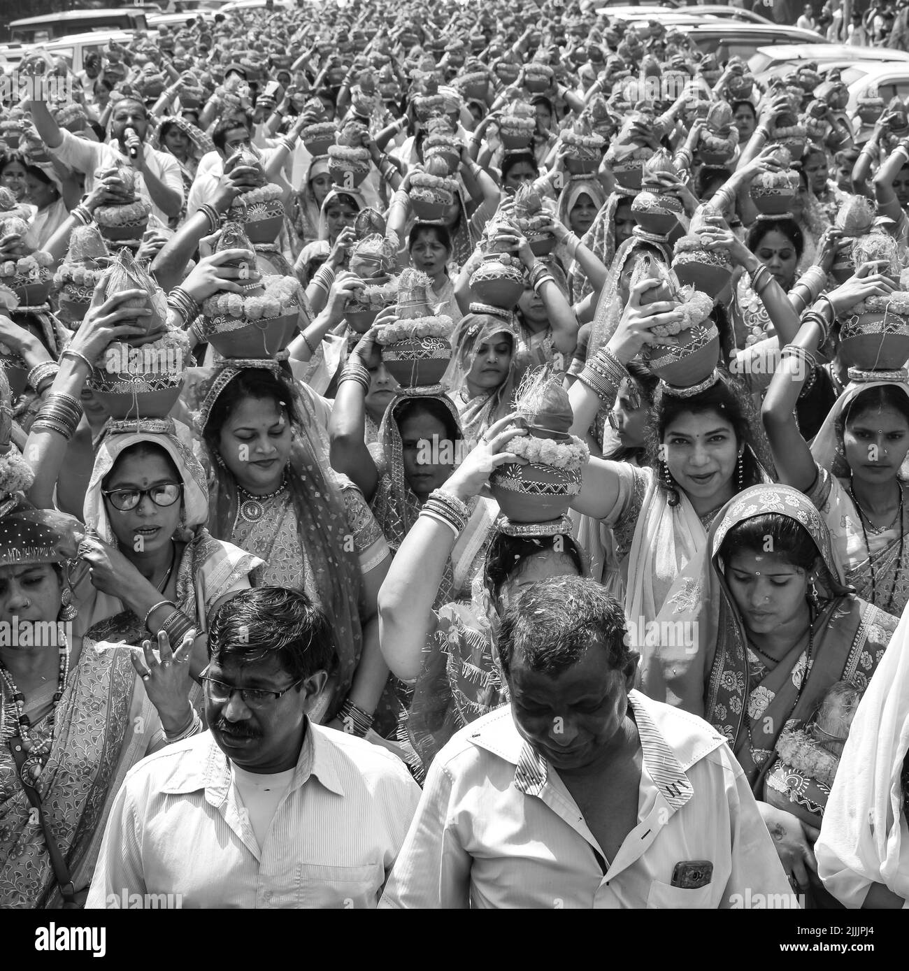 Delhi, Indien April 03 2022 - Frauen mit Kalash am Kopf während des Jagannath-Tempels Mangal Kalash Yatra tragen indische Hindu-Anhänger irdische Töpfe im Container Stockfoto