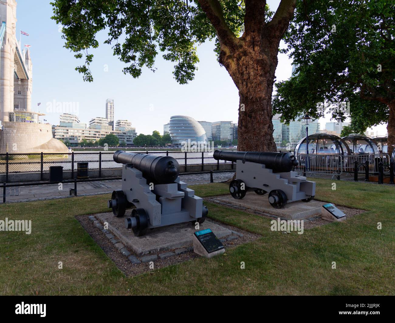 London, Greater London, England, Juni 22 2022: Kanonen an der Themse mit Rathaus, Tower Bridge und Glass Rooms Restaurant. Stockfoto