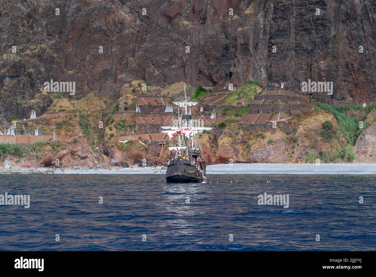 MADEIRA, PORTUGAL - 25. AUGUST 2021: Dies ist ein Vergnügungsboot in Form der historischen Santa Maria Karavelle mit Urlaubern an den felsigen Ufern von Stockfoto MADEIRA, PORTUGAL - 25. AUGUST 2021: Dies ist ein Vergnügungsboot in Form der historischen Santa Maria Karavelle mit Urlaubern an den felsigen Ufern von Stockfoto