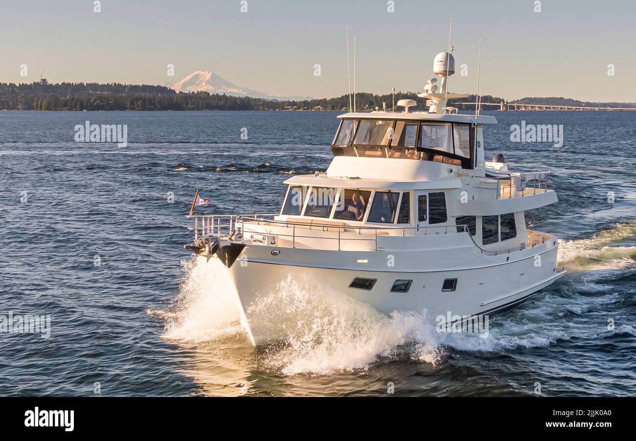 Eine weiße Yacht, die mit Wasserspritzern auf dem Meer schwimmt Stockfoto