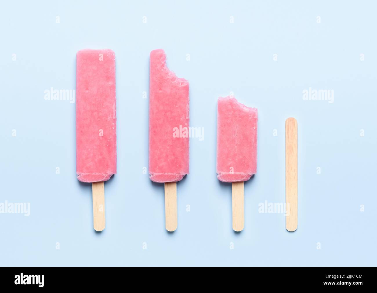 Pink Popsicle Eis auf Holzstock Verbrauch Lebenszyklus auf blauem Hintergrund Draufsicht flach legen Stockfoto