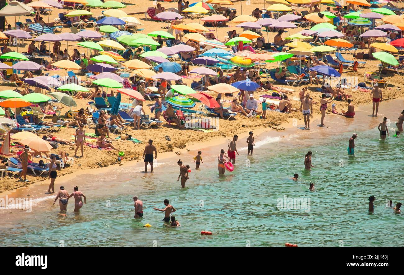 Golden Bay, Mellieha, Malta - Juli 24 2022: Ein überfüllter Sandstrand mit grün türkisfarbenem Wasser Stockfoto