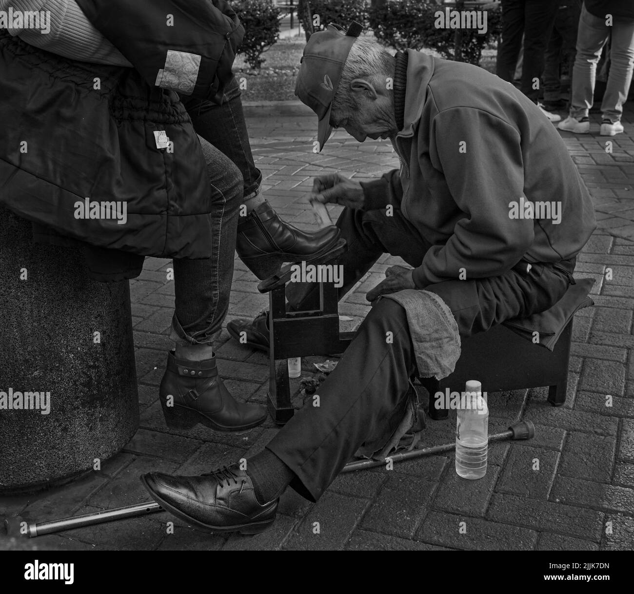 Nahaufnahme eines alten Mannes, der die Schuhe einer Frau vor dem Mercado Central in Lima, Peru, poliert Stockfoto