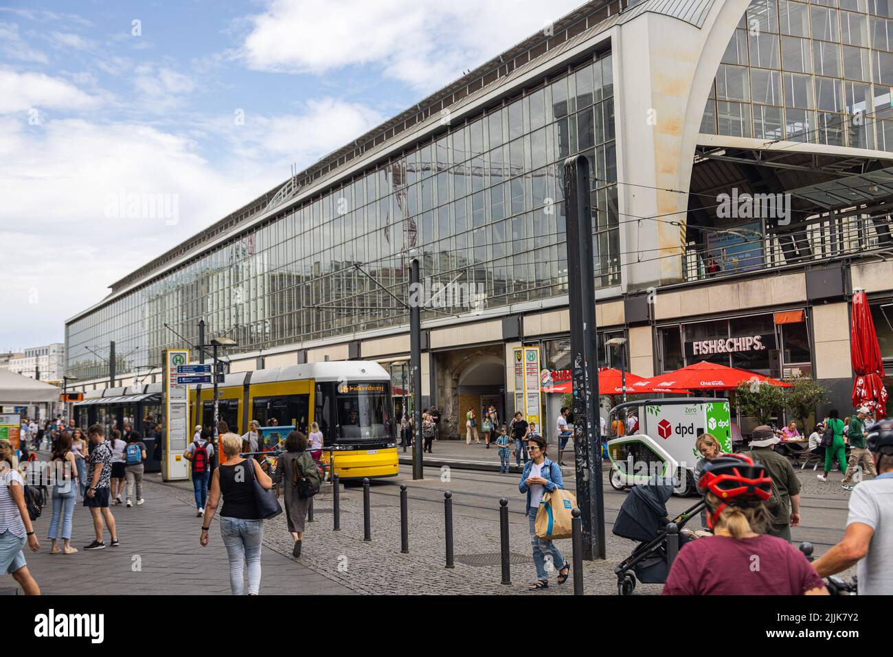 Berlin, Deutschland - 29. Juni 2022: Bahnhof Berlin Friedrichstraße mit einer Straßenbahn an der Straßenbahnhaltestelle. Geschäftiges Hotel in Ostberlin. Die Menschen sind wai Stockfoto