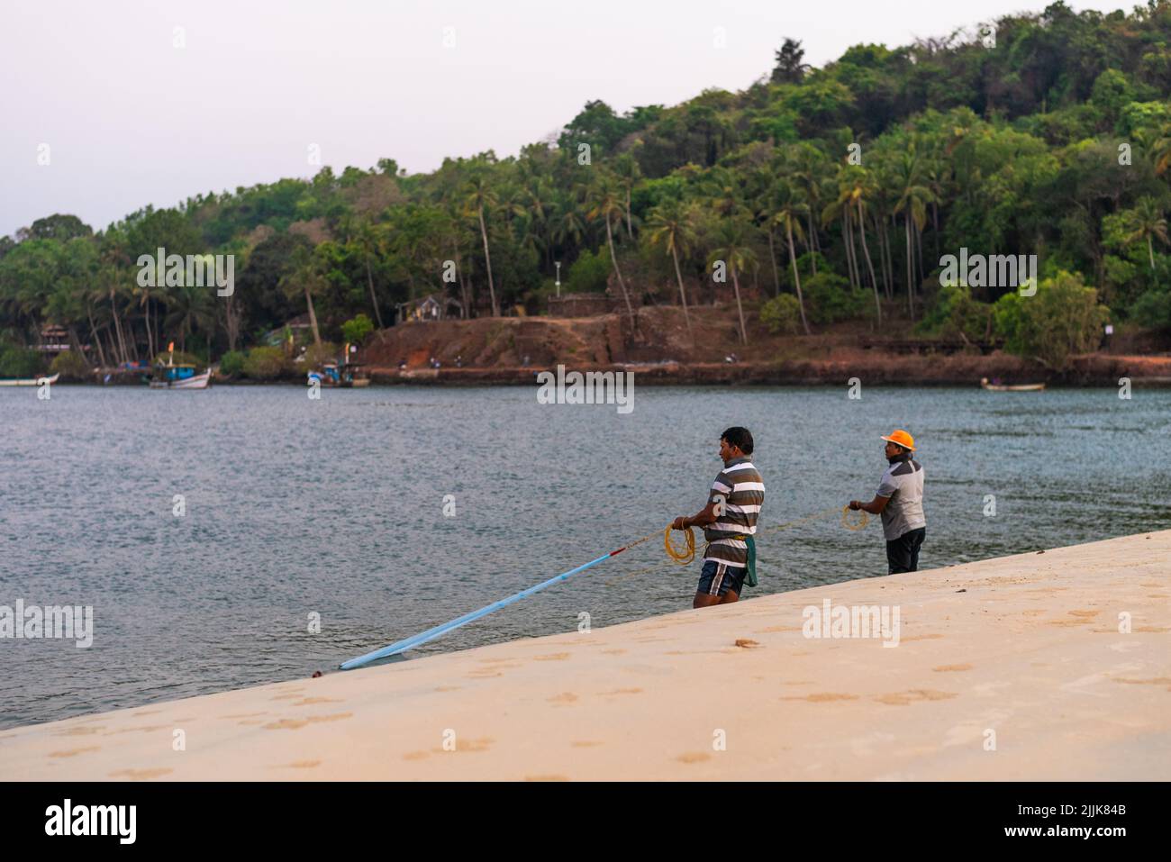 Einheimische indische Fischer werfen Netze in das Meer im Dorf Betul, Salcete, Goa, Indien Stockfoto