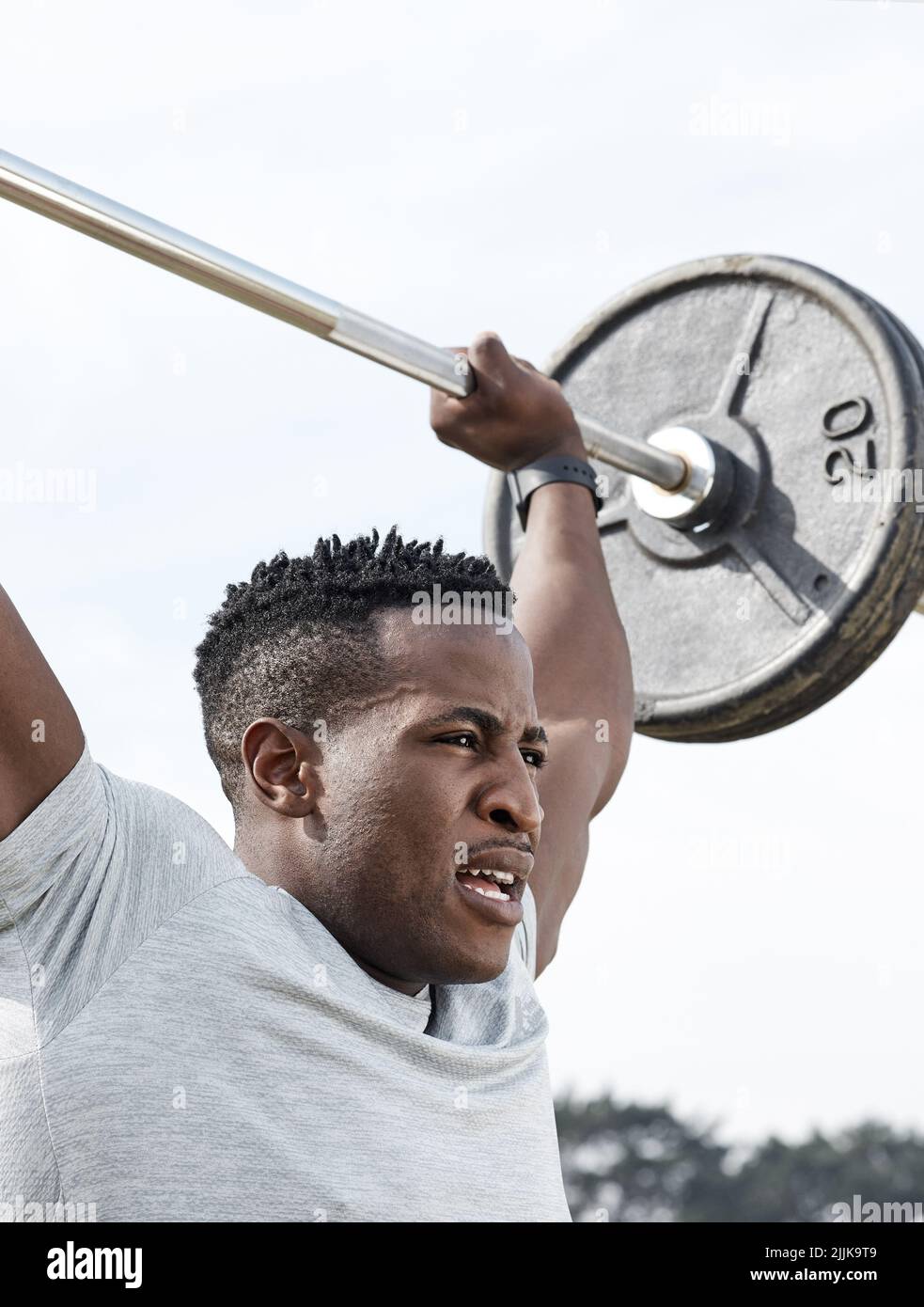 Jeder Tag ist eine Chance, besser zu werden. Ein Mann mit einer Langhantel beim Training im Freien. Stockfoto