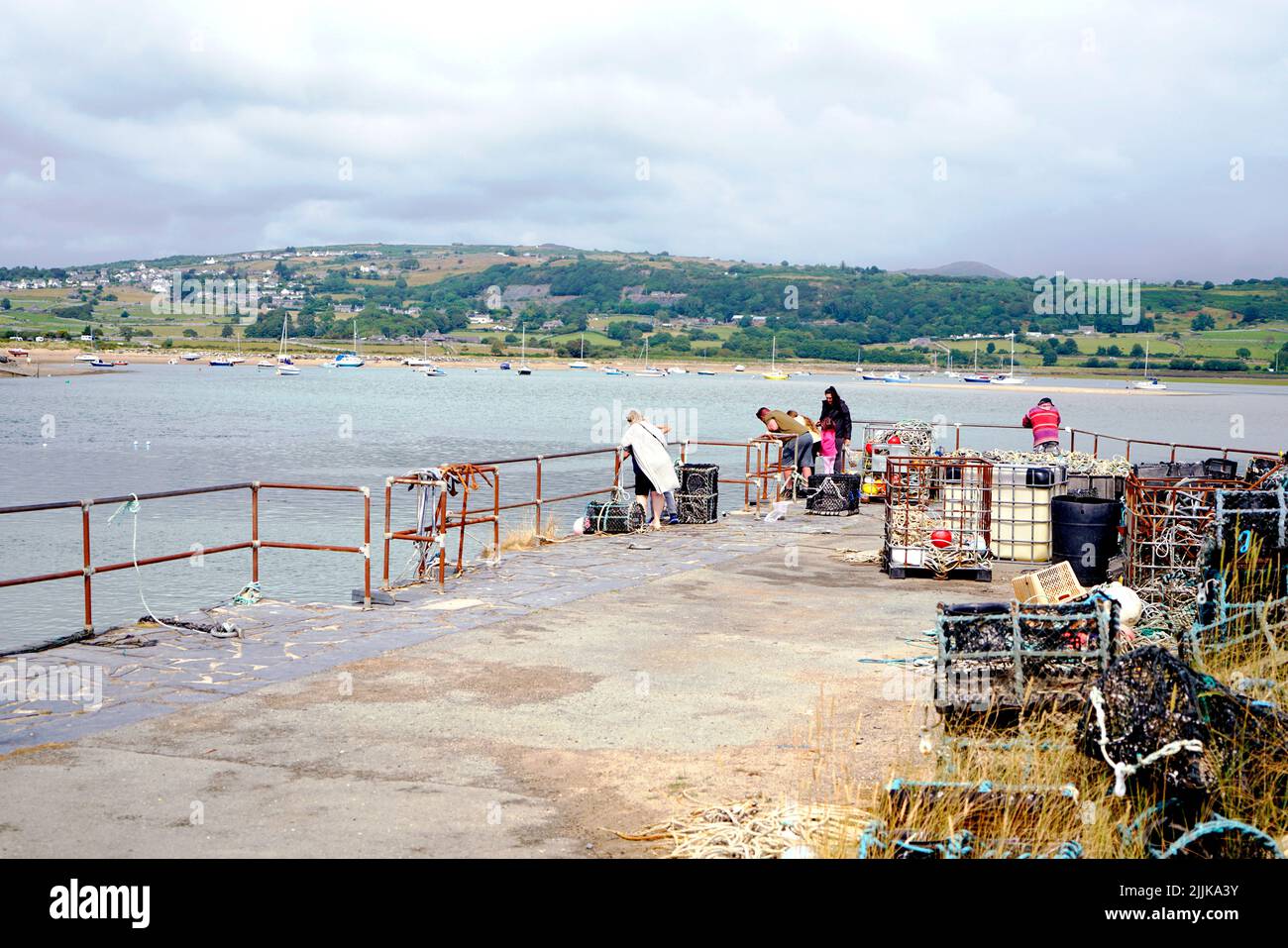 Urlauber, die am Quay am Hafen von Shell Island mit Blick auf Harlech in Wales krabben. Juli 2022. Stockfoto